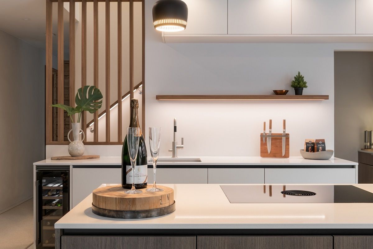 I faretti sul soffitto, proprio davanti ai mobili della cucina, illuminano l'area di cottura